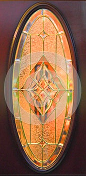 Antique Art Deco style oval stain glass window, geometric design.