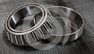 Automotive tapered roller bearing and race on carbon fiber cloth photo