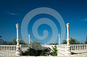 Antique balustrade with entrance to the garden and clear blue sk