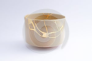 Antique beautiful broken bowl restored with kintsugi gold technique photo