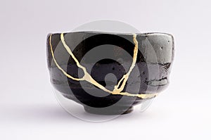 Antique beautiful broken raku bowl restored with kintsugi gold technique photo