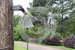 Antique bell at the entrance to the ranch near the roads