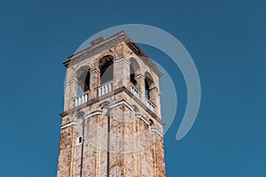 Antique bell tower in Venice with clear blue sky in the background