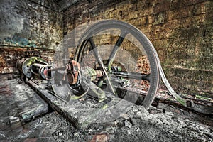 Antique belt driven steam engine in an abandoned factory