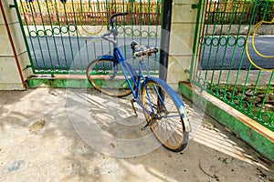 An antique bicycle was parked near the fence