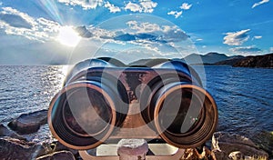 Antique binocular on rock in beach