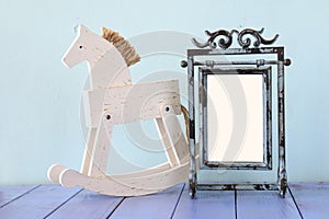 Antique blank vintage style frame and old rocking horse over woo