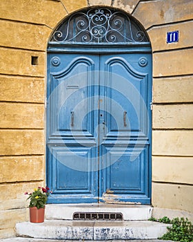 Antique blue wooden door and flowers on marble steps