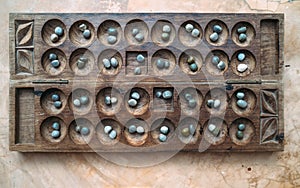 Antique Boa Mancala tradition African Board Game. Vintage Bao carved wooden Board Game. With natural baobab tree seeds Balls