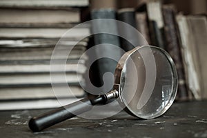 Antique books with magnifying glass.