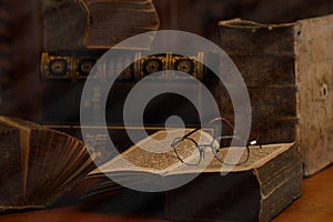 Antique books with reading glasses in a dusty room