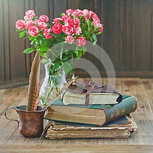 Antique books stack lies on a wooden table.