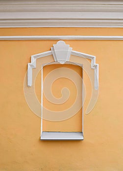 Antique bricked window painted with yellow paint.