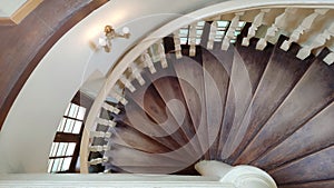 Antique brown wooden spiral staircase.