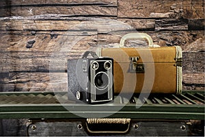 Antique camera and vintage suitcase with wood background