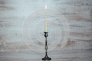 Antique candlestick with a burning candle