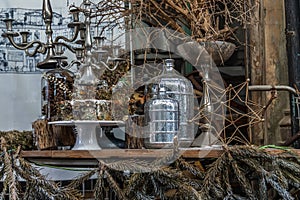 Antique candlestick and Dry plant, Dried flowers, Pine cones with Glass bottle Decorate on wooden table in cafe