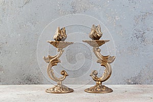 Antique candlesticks on concrete background