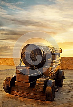 Antique cannon on nuclei at sunset