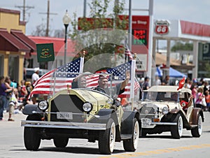 Antique car with American Flags in parade in small town America