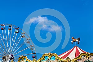 Antique carousel horses tent and colourful ferris wheel