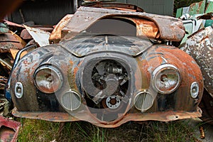 Antique cars on a big scrapyard at the end of Old Coach Road Trail, New Zealand