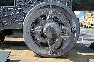 Antique cast-iron gun carriage wheel with a beautiful pattern on the background of a building in the Kremlin, Moscow.