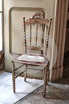 Antique chair in golden leaf in a room of an ancient noble villa