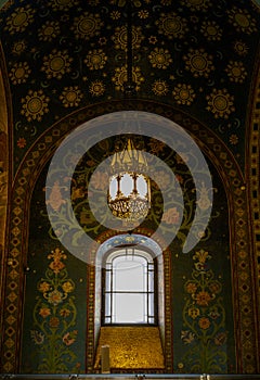 Antique chandelier and window on a mosaic-covered wall in the Church of the Savior on Spilled Blood in St.Petersburg photo