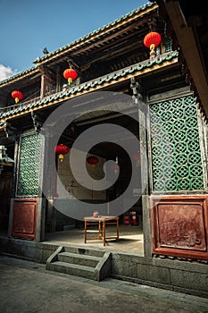 Antique Chinese building entrance adorned with red lanterns. Fujian province, Longyan City, China.