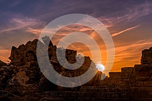 Antique city ruins under sunset with scattered clouds