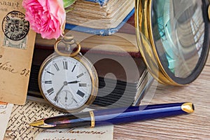 Antique clock on old books and letters background