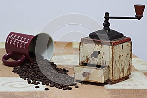 Antique coffee grinder and a coffee mug and beans