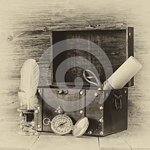 Antique compass, inkwell and old wooden chest on wooden table. black and white style old photo