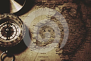 Antique compass  at old Australia map.