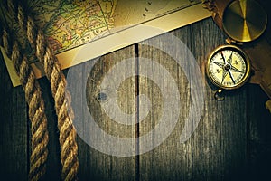 Antique compass and rope over old map