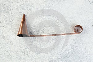 Antique copper candle snuffer on concrete background