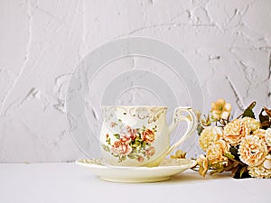 Antique cup of tea with saucer ,yellow orange rose flowers