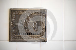 Antique damper in the Russian stove with the image of a horseman photo