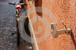 An antique decorative window shutter and a blury bike in the background