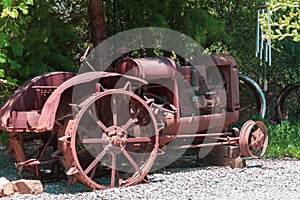 Antique depression era tractor retired under a shade tree