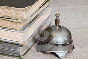 Antique desk bell beside an old stack of books