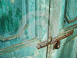 Antique door with chipped blue paint and rusted lock