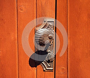 Antique doorknob on a wooden door, closeup. Antique metal door handle. Old wooden entrance door with antique door handle