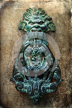 Antique doorknocker on grunge texture