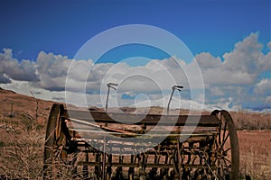 Antique farm equipment in front of snow capped mountains