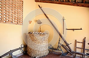 Antique farm tools and yellow wall
