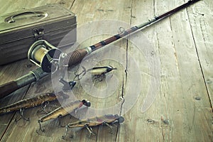 Antique Fishing Rod and Lures on a Grunge Wood Surface