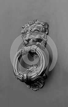 Antique forged lion head door knocker. Vintage design. Black and white photography