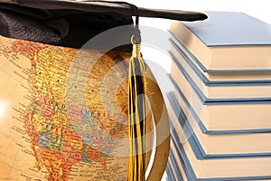 Antique globe, graduation cap and books